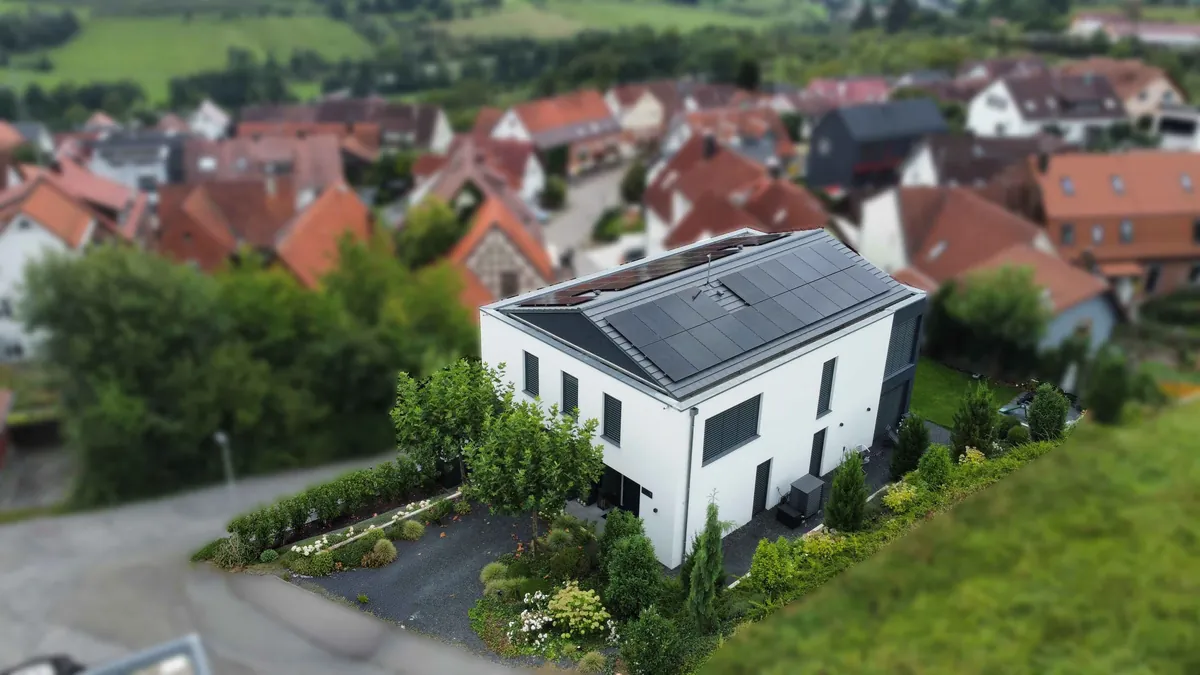 Weißes Wohnhaus mit Solaranlage, Luftaufnahme