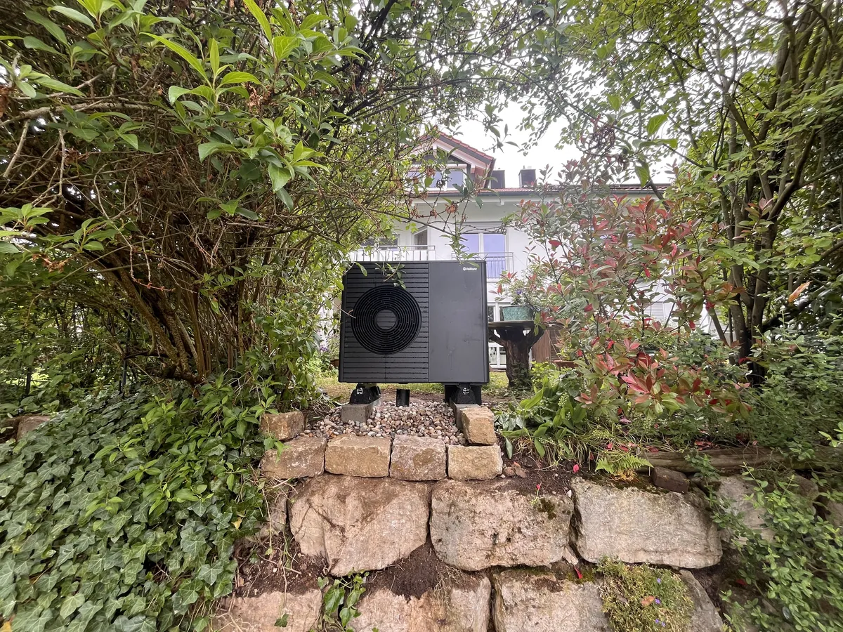 Außeneinheit der Wärmepumpe bei Frau T. vor einer Natursteinmauer